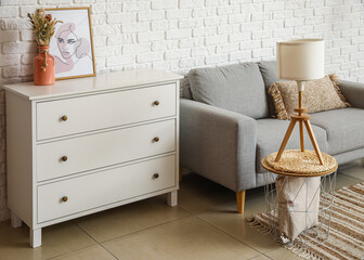 Interior of light living room with commode, lamp and coffee table