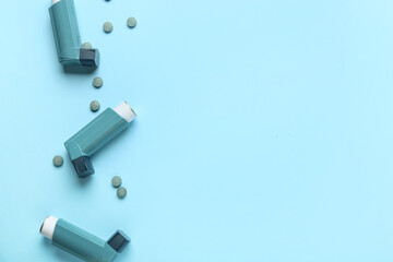 Modern asthma inhalers and pills on blue background