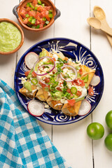 Mexican fried potato tacos called flautas with guacamole and cheese