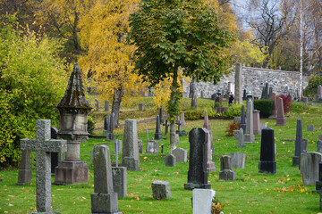 Fototapeta premium Old cemetery and tombstones in the park in autumn