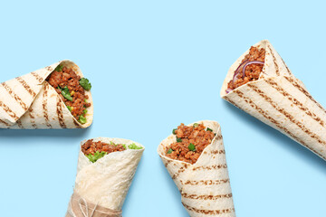 Different tasty burritos on blue background