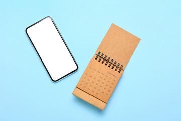 Craft calendar and mobile phone on blue background