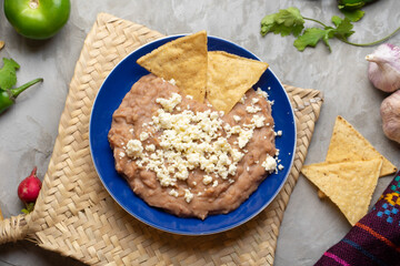 Mexican refried beans with cheese and totopos