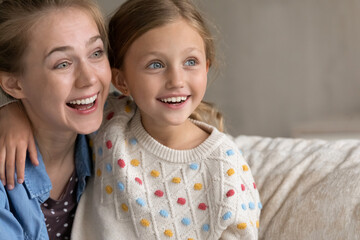 Head shot inspired happy affectionate young mum and small adorable kid daughter looking in...