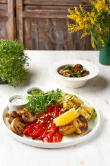 Grilled vegetables eggplant, zucchini, pepper salad with tzadziki Greek yogurt sauce on a light background, top view. Delicious appetizer, tapas, snack