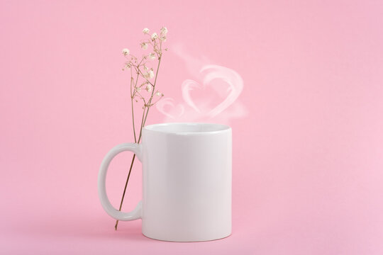 Mockup white coffe cup or mug on a pink background. Hot drink steam in the form of heart
