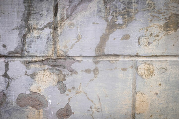 Damaged wall with holes texture background. Creative backdrop. Old, abandoned building interior fragment. Weathered and cracked bricks with concrete, peeled off paint and moss. Close up, copy space