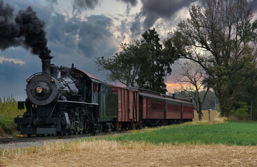 Fototapeta na wymiar An Antique Restored Steam Freight Train Approaching Head on Blowing Smoke and Steam