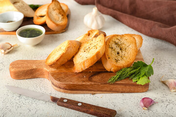 Wooden board of tasty croutons on light background