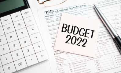 BUDGET 2022 with pen, calculator, glass and sticker. Tax report sign