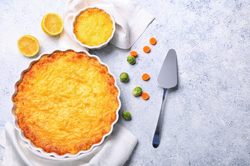 Baking dish and pot with tasty English fish pie on light background