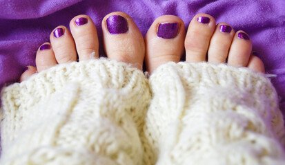 Women legs, purple pedicure. White socks.