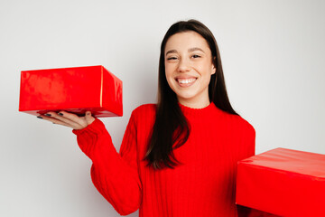 Pretty girl is holding the gifts and smiling. The girl is happy to receive nice gifts. Concept of the Valentine's Day