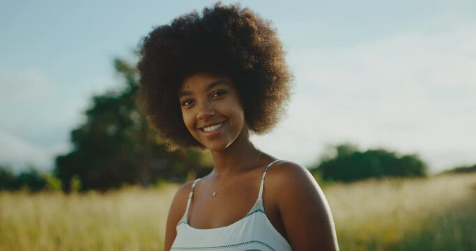 Portrait of beautiful young black woman smiling at sunrise, afro fashion lifestyle