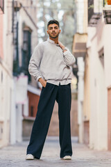 Young man standing while looking at the camera with a proud expression outdoors