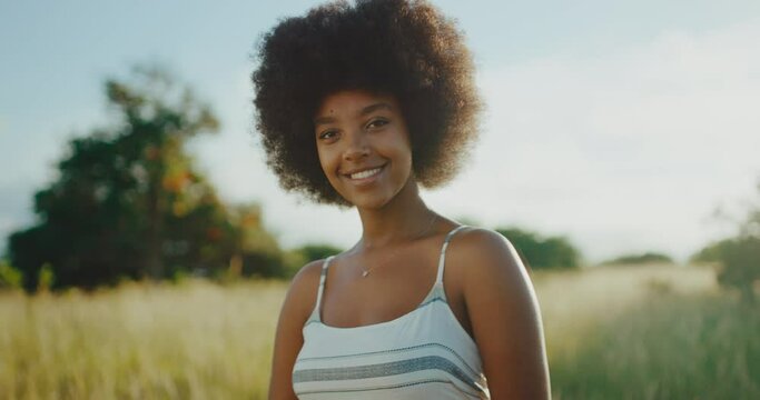Portrait of beautiful young black woman smiling at sunrise, afro fashion lifestyle