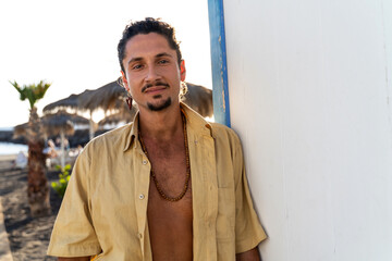 Portrait of calm handsome hippie italian man with smile looking at the camera, relaxing on the...