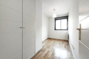 Entrance to an empty bedroom with lacquered wooden doors and French oak parquet flooring