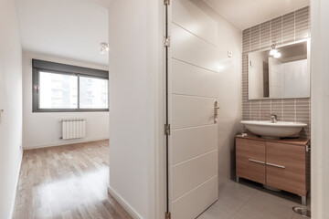 Empty bedroom with large window and en suite bathroom with parquet floors