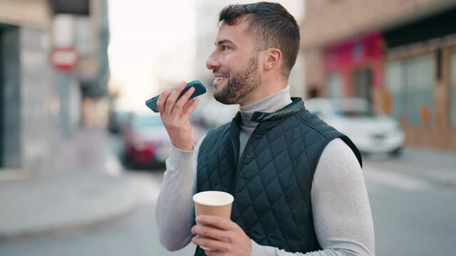 Young hispanic man talking on the smartphone drinking coffee at street