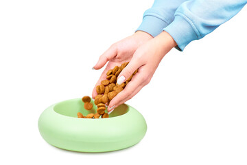 Woman pours from hands dry dog food into a bowl isolated on white background Close-up