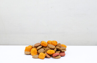 dog food, brown and orange colored kibble against a white background
