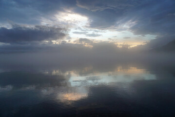 Fototapeta na wymiar 北海道支笏湖の湖畔。夕陽が空から垣間見えて幻想的な風景