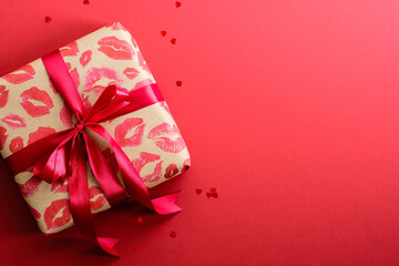 Valentines day gift box and confetti on red background. Top view with copy space, flat lay. Happy Valentines day banner design.