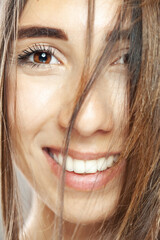 Beautiful brunette girl studio portrait. Smiling face expression.