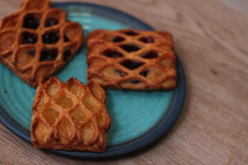 Lattice Jam Tart served in a plate on a wooden table.