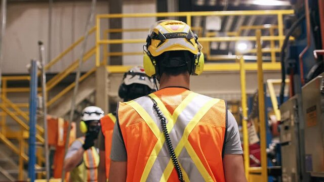 construction safety workers walking in slow motion through factory