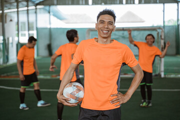 Cheerful male futsal player poses standing with thumbs up