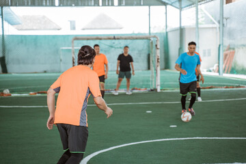 Players in orange uniforms are ready to snatch the ball