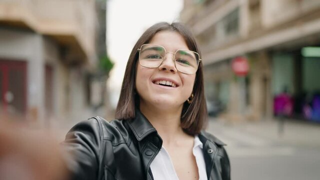 Young hispanic woman smiling confident having video call at street