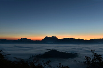 Fluffy sea of fog in a valley of Doi Luang Chiang Dao mountain with twilight sky background in sunrise time, Thailand