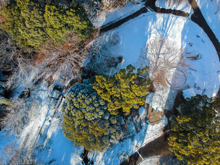 ドローンで空撮した冬の雪が積もった朝の公園の風景