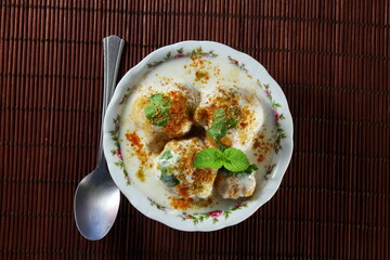 homemade traditional indian gujarati snack food dahi vada or thayir vadai in bowl, top view 
