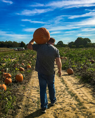 man pumpkin picking in the fall