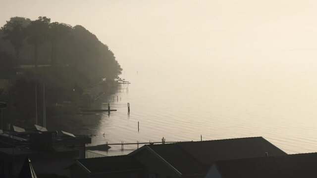Houses with privat boot docks jetty at calm bay in the morning foggy early in scandinavia