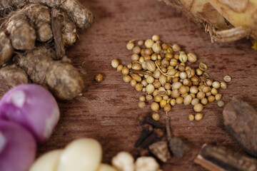 Coriander, ginger, onion, garlic and other spices on wooden base