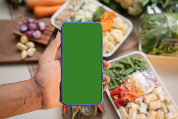 Blank screen of a cell phone with fresh vegetables
