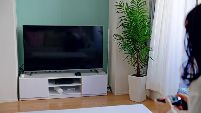 テレビゲームで遊ぶ女性