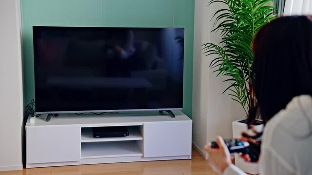 テレビゲームで遊ぶ女性