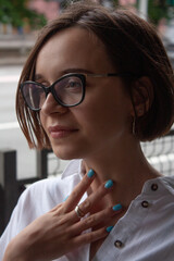 A young woman with short brown hair, wearing a white shirt
