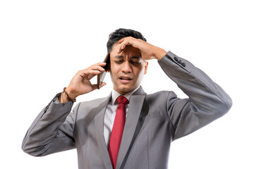 stressed young man wearing suit hold his head while making a phone