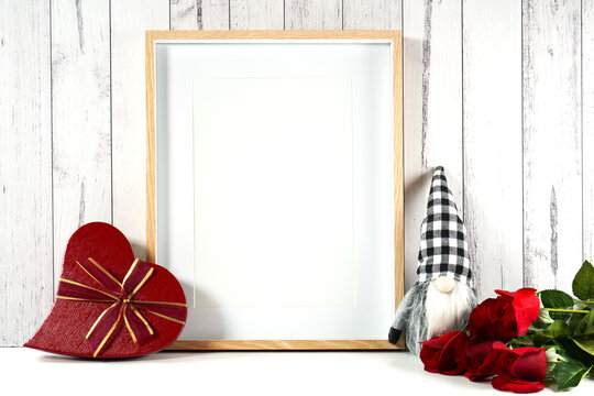 Wall art print frame product mockup. Valentine's Day farmhouse theme SVG craft product mockup styled with red roses, heart shaped gift, and buffalo plaid gnome against a white wood background.