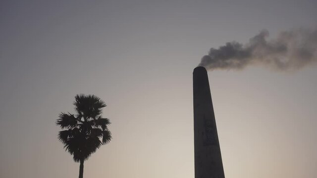 Smoke is coming out of the furnace which is mixed with the air.