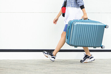 Female traveler walking with blue suitcase on white background