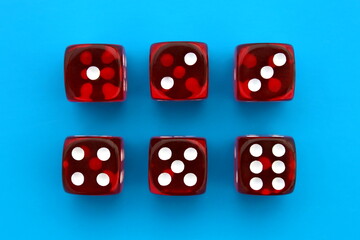 Six red dice lie on an isolated blue background.