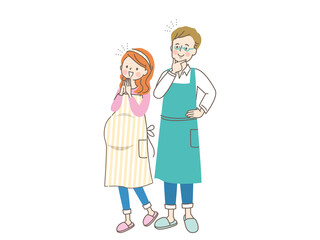 妊娠中の笑顔の女性とエプロン姿の夫
